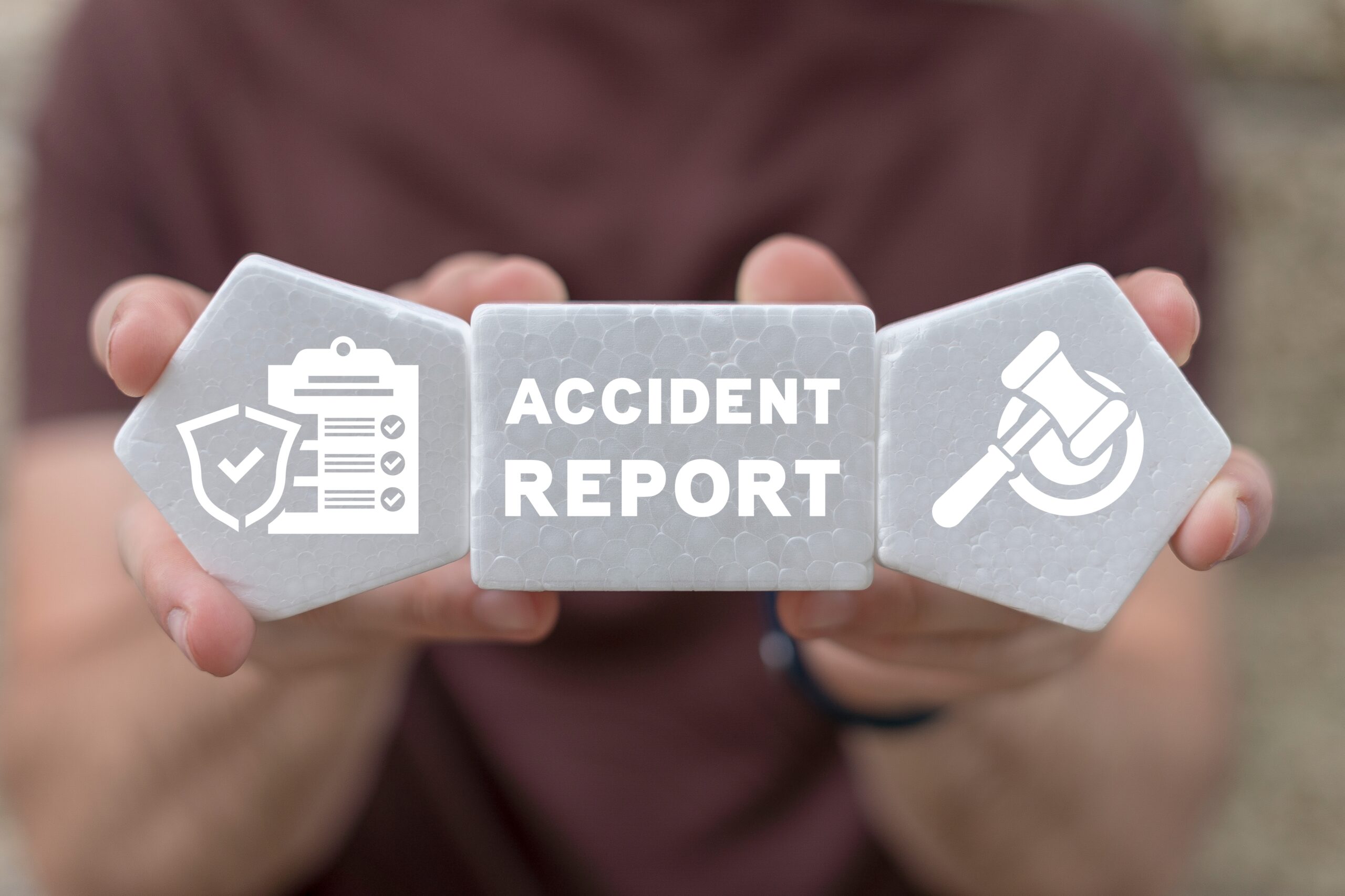 man holding plastic blocks with accident report text written on them