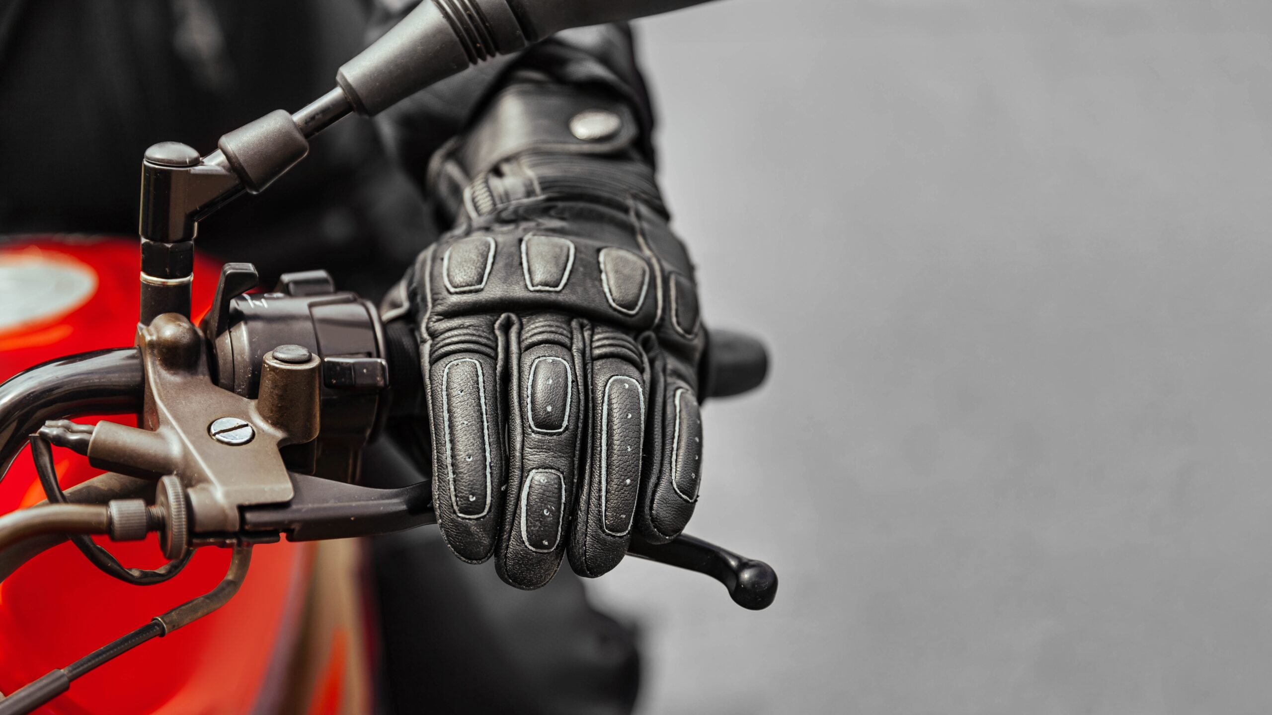 Hand in glove on motorcycle grip representing importance of Birmingham motorcycle accident lawyer