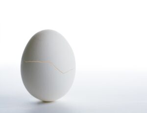white egg standing on end with crack through center