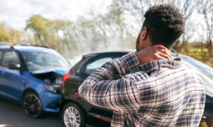 Man rubs neck after car accident, considering what Birmingham car injury lawyer to call.