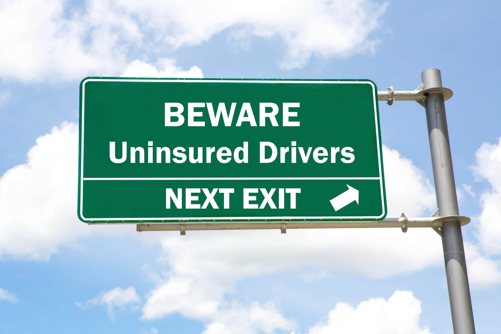 roadsign with bluesky behind it reading "beware, uninsured drivers next exit"
