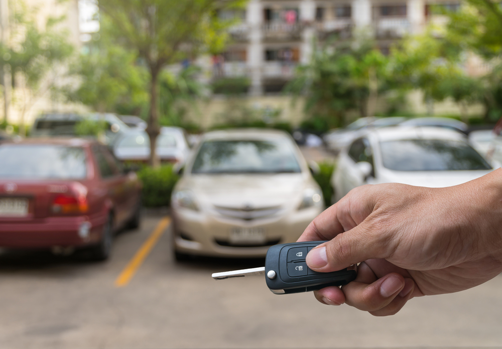 Hand holding car keys in parking lot to obtain rental car after a car accident